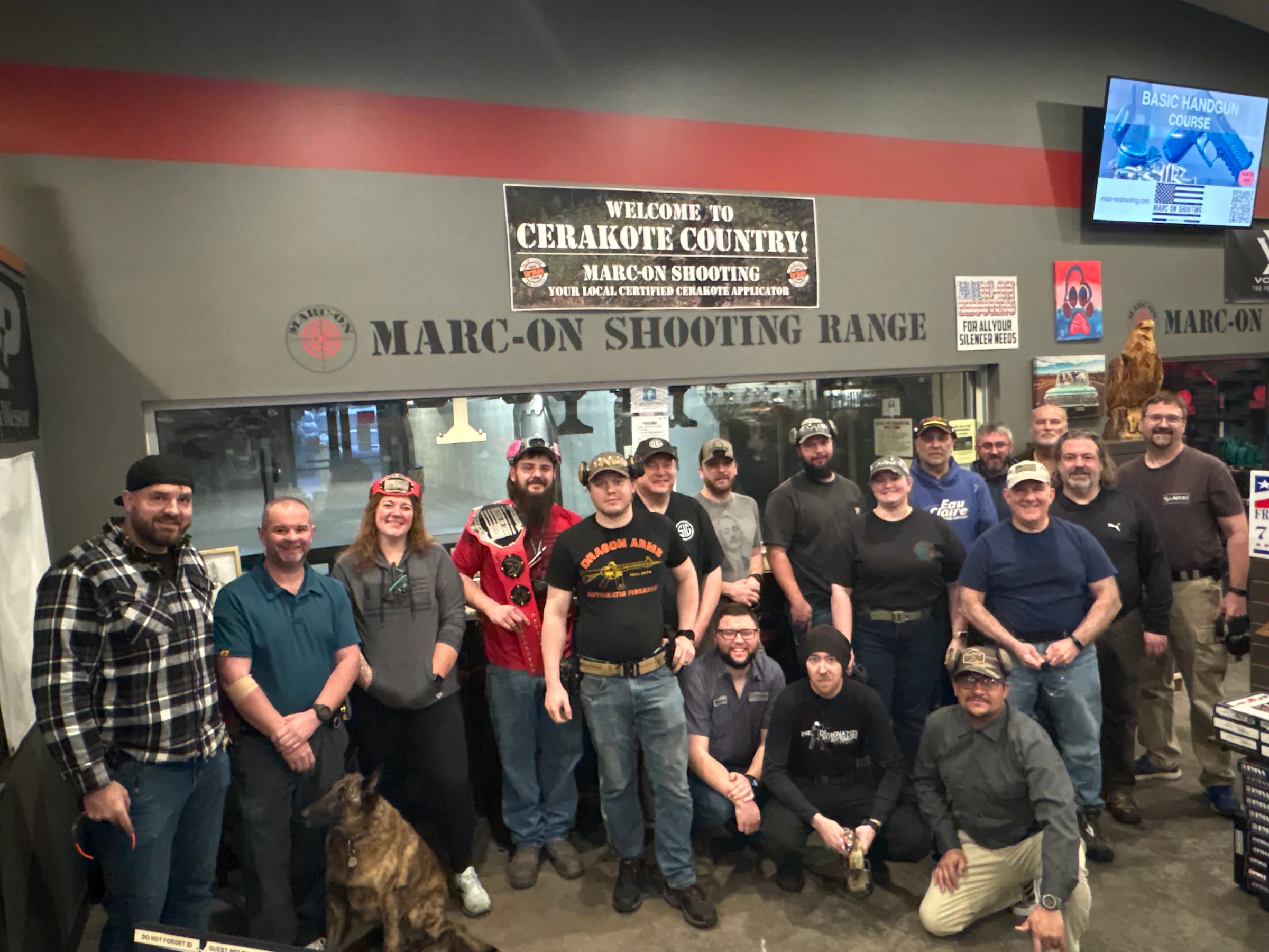 A large group of Marc-On shooters and team members gathered beneath the range sign