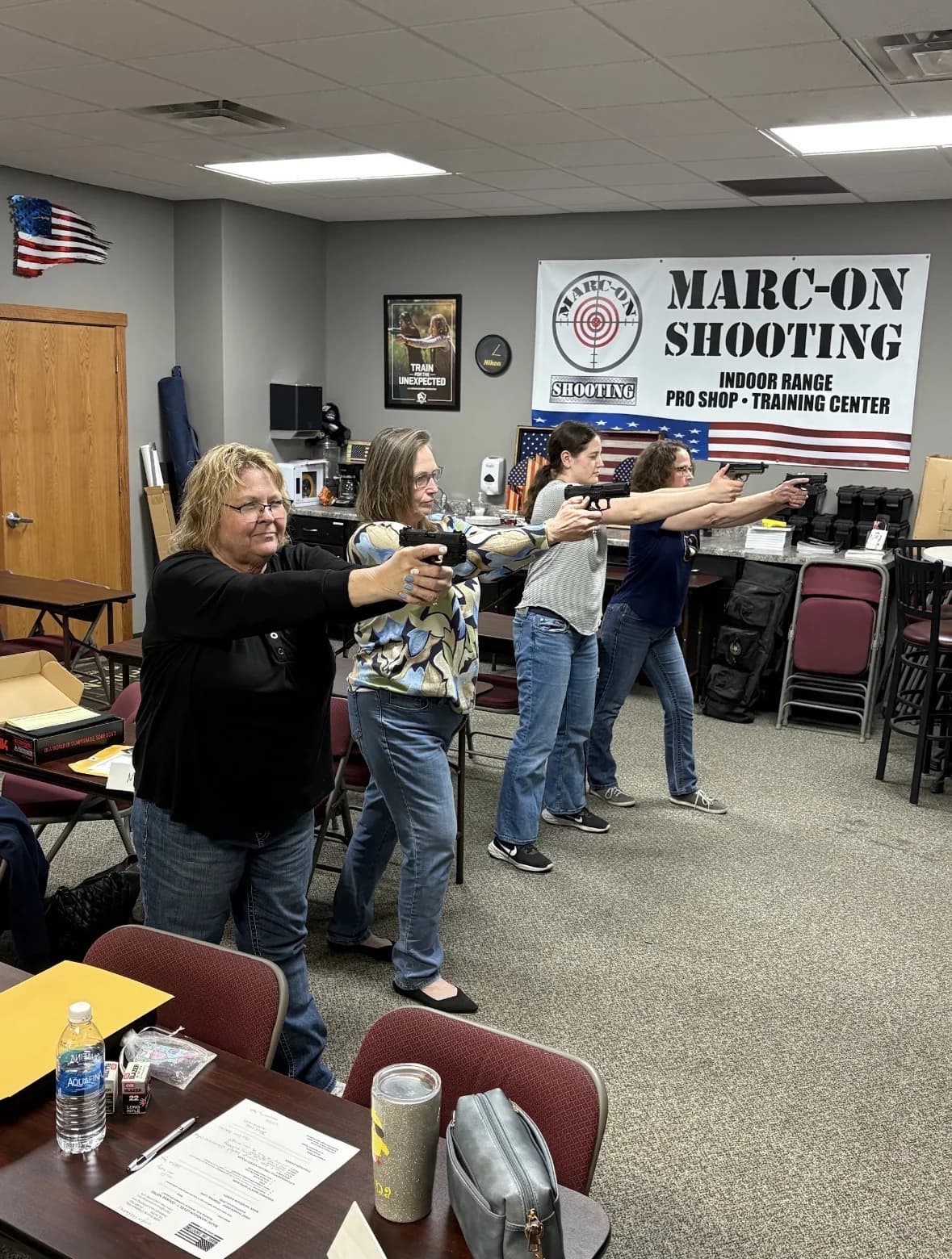 Four women practicing safe handgun presentation during a Marc-On classroom lesson