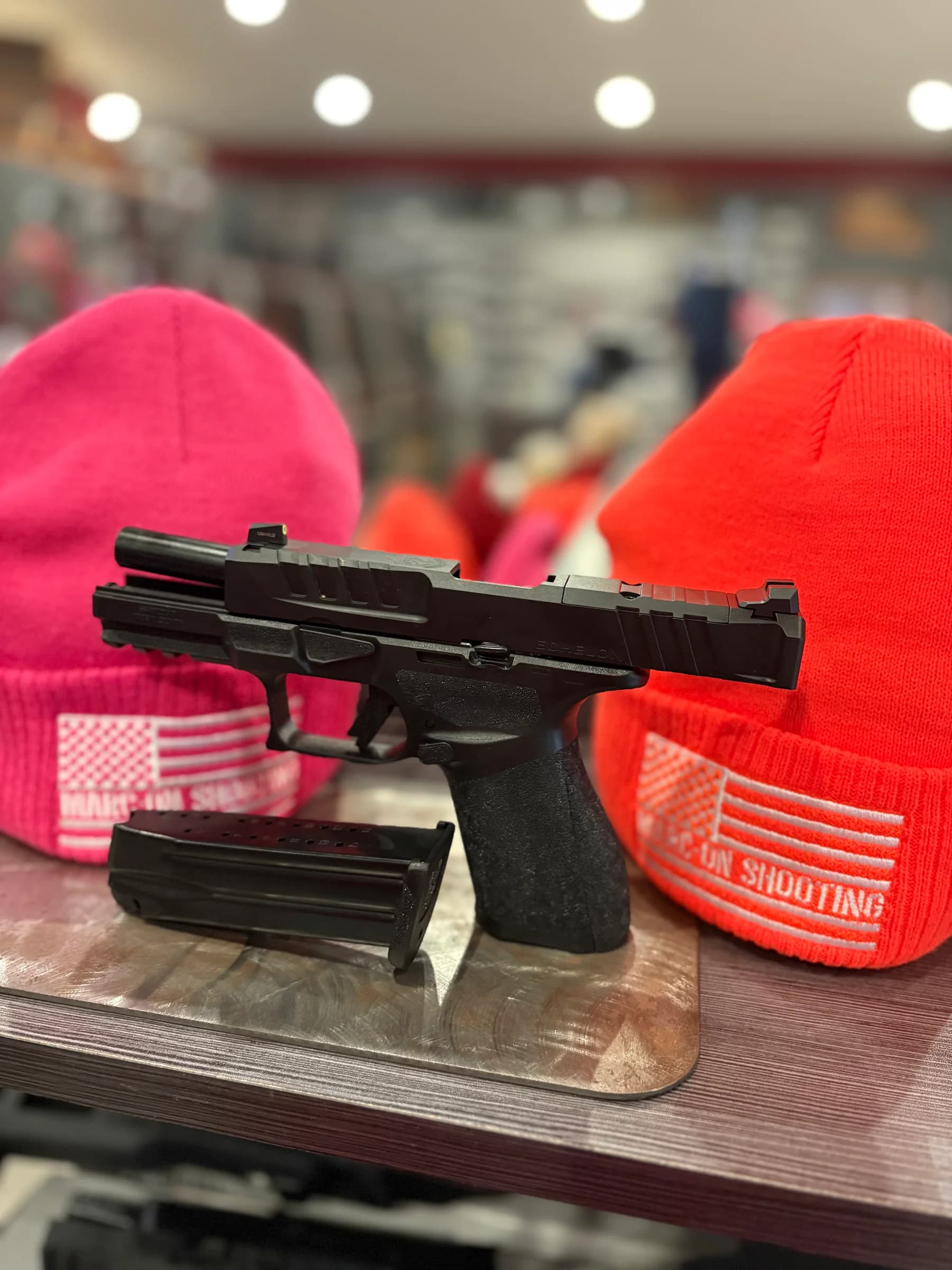 A handgun displayed with Marc-On branded knit hats