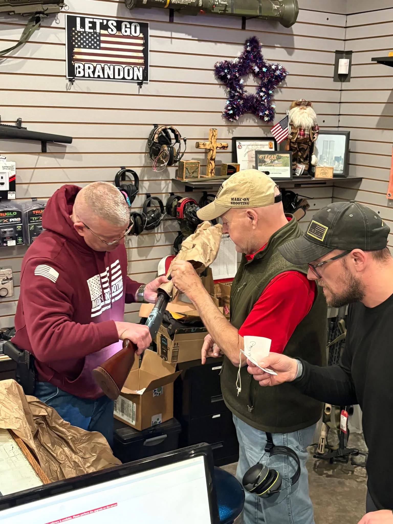 Marc-On team members helping a customer examine a long gun in the pro shop